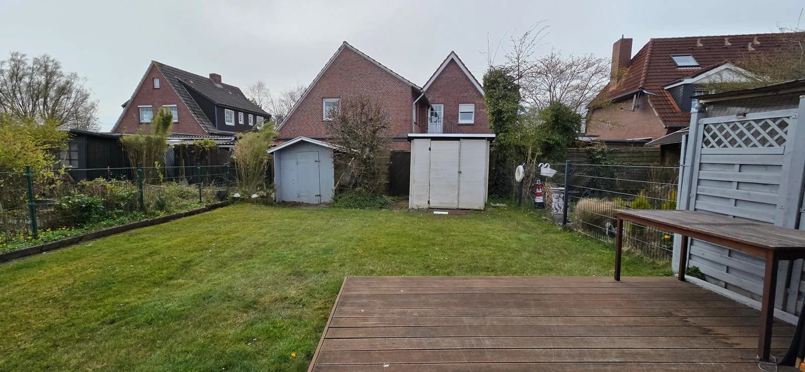 Gepflegter Garten mit Rasenfläche und Holzterrasse