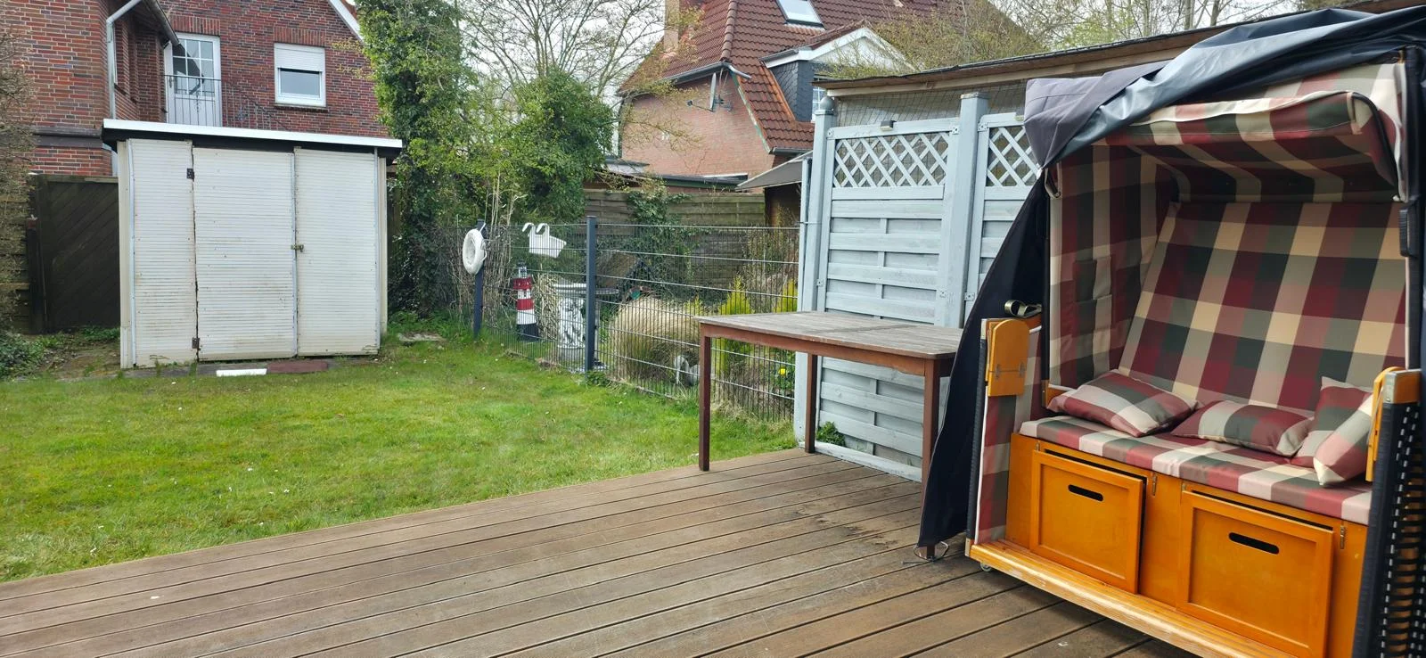 Holzterrasse mit Strandkorb und Garten