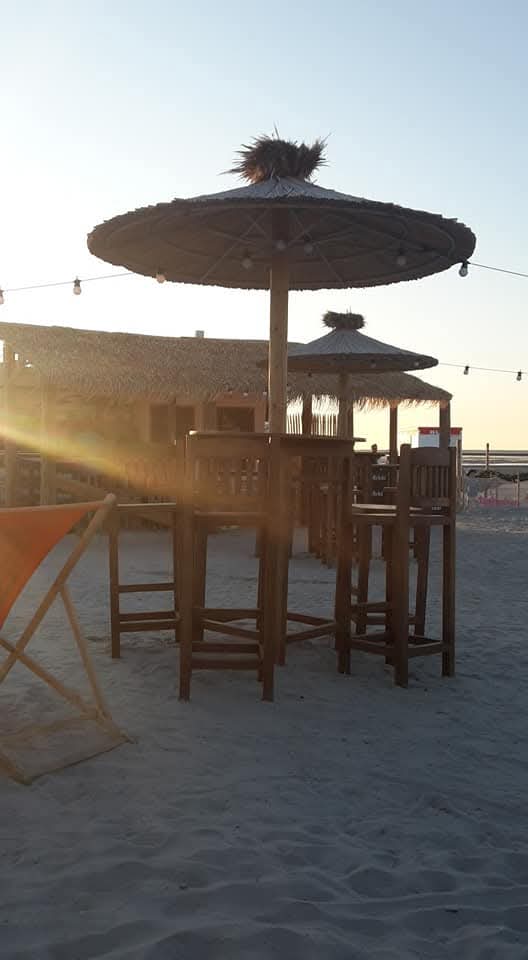 Strandbar mit Sonnenschirmen im Abendlicht